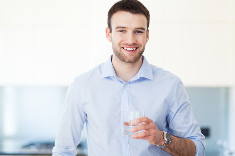 man holding glass of water